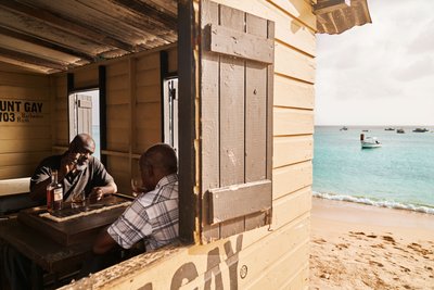 Entspanntes Gespräch zwischen 2 Maennern in einer Strandhütte