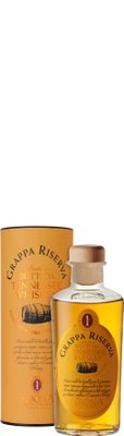 Die Flasche mit Grappa Riserva hat einen Holzverschluss und steht neben einer dekorativen Box, die Whiskey-Fässer abbildet.