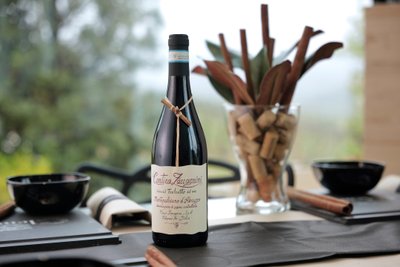 Eine Flasche Montepulciano d'Abruzzo steht auf einem Tisch, umgeben von stilvollen Dekorationen und einem Glas mit Korken.