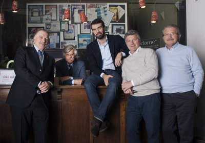 Fünf Männer in formeller Kleidung in einem geschmackvollen Lokal