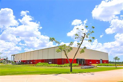 Moderne Lagerhalle mit grünem Rasen unter blauem Himmel