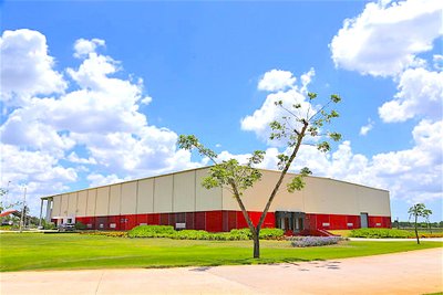 Moderne Lagerhalle mit grünem Rasen unter blauem Himmel